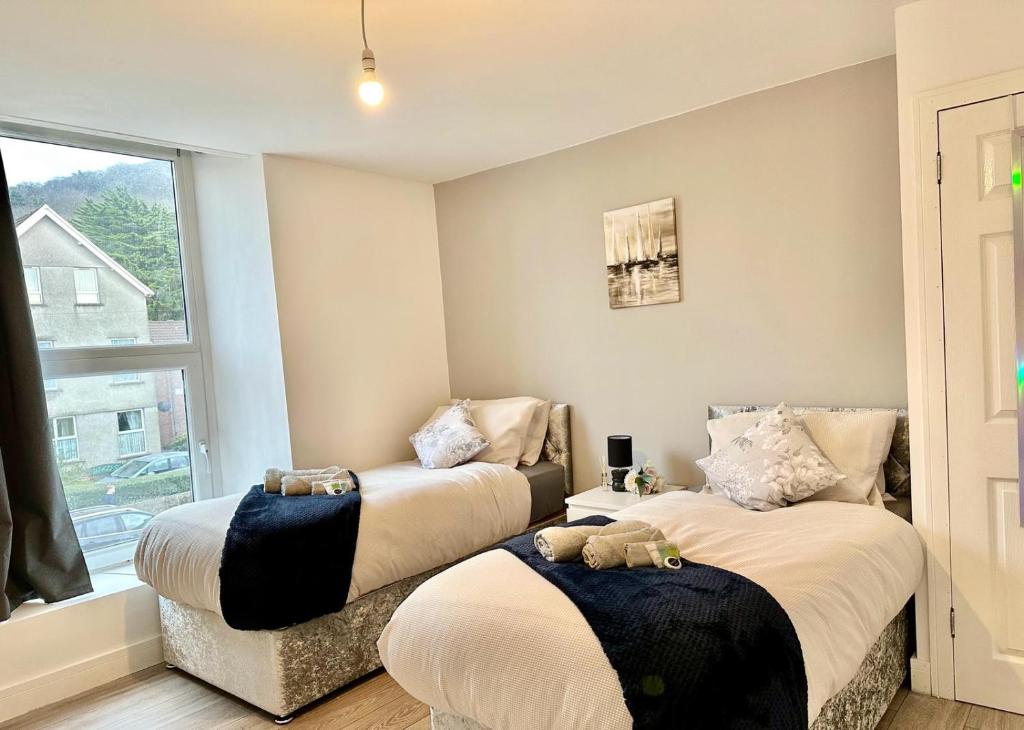 1 dormitorio con 2 camas con animales de peluche en Cosy Modern 2 Bedroom Apartment bedroom with ensuite bathroom - Neath Road Port Talbot Near Briton Ferry Train Station, en Briton Ferry
