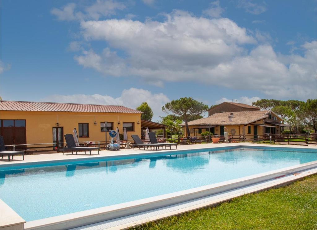a large swimming pool with chairs and a house at Terre Dell'Amore in Grosseto