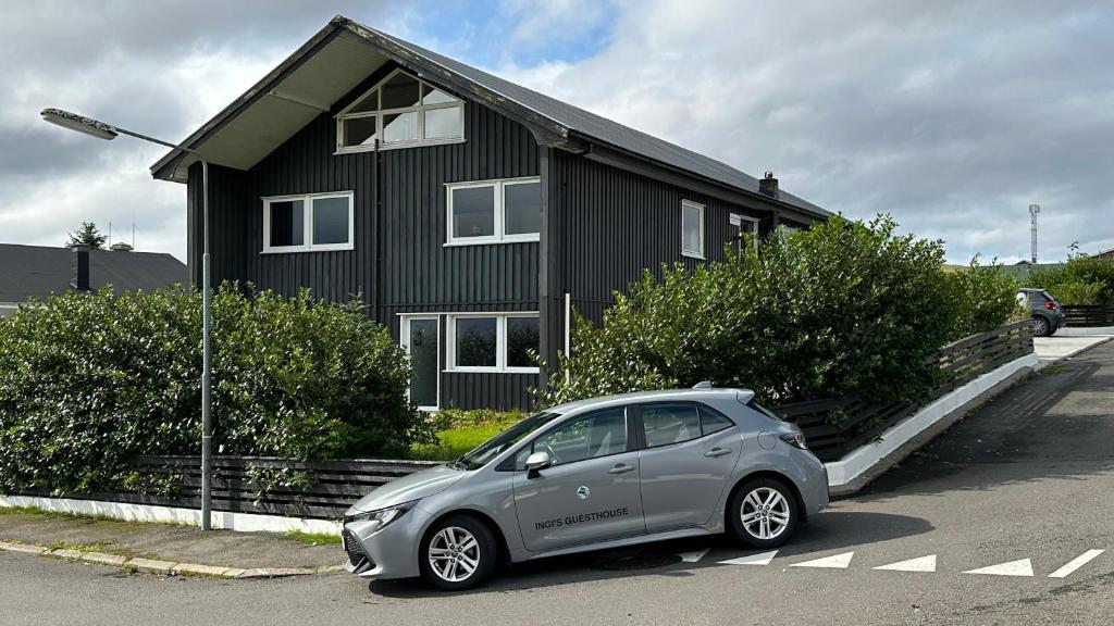 un pequeño coche aparcado frente a una casa en Ingi's Guesthouse with a Car, en Miðvágur