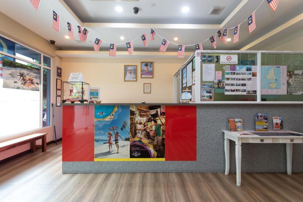 uma sala de aula com uma mesa e bandeiras na parede em Capital O 89344 Labuan Avenue Hotel em Labuan
