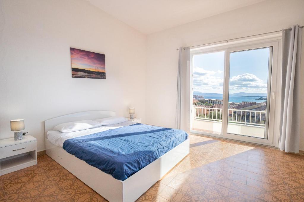 una camera bianca con un letto e una grande finestra di Tramontana vista mare 300m dalla spiaggia a Golfo Aranci
