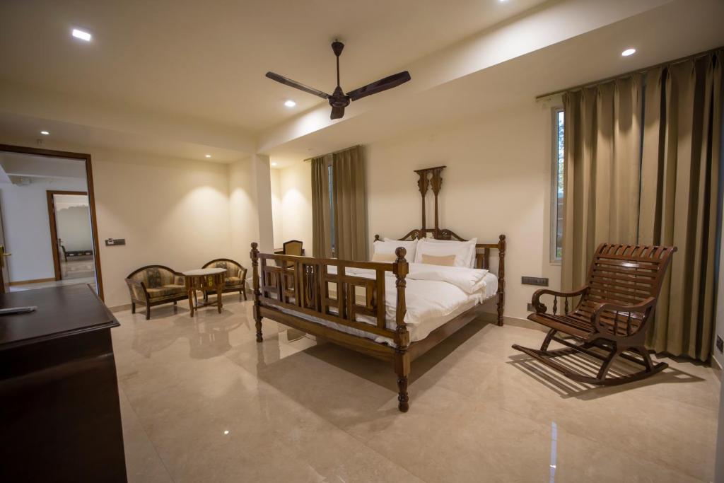 een slaapkamer met een bed en 2 schommelstoelen bij ASHOK VILLA in Jaipur