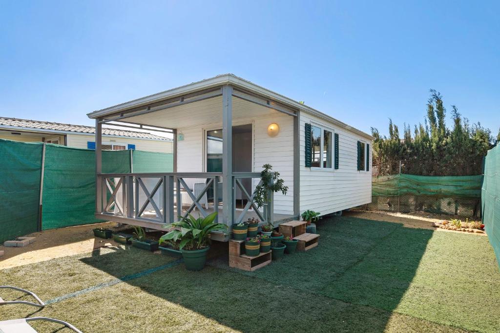 ein kleines weißes Haus mit Pflanzen im Hof in der Unterkunft Linda casita in El Palmar