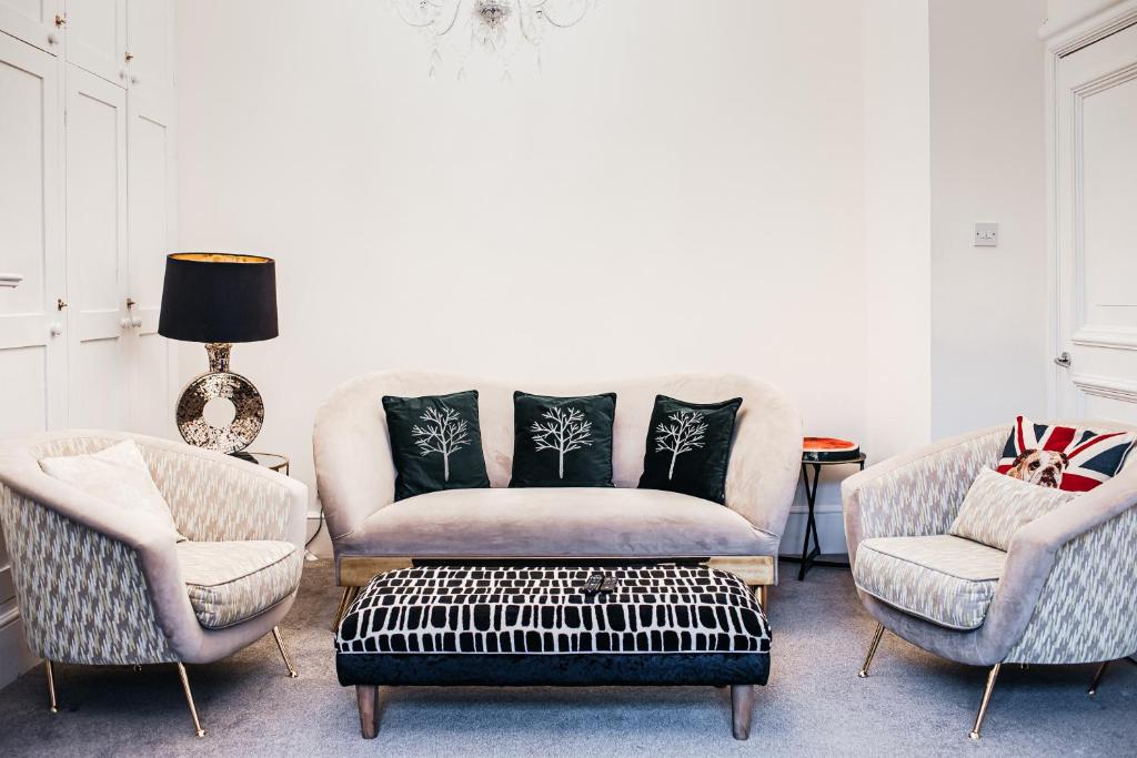 - un salon avec deux chaises et un canapé dans l'établissement Central Windsor Spacious Three Double BedRooms, Two Living Room, Kitchen Entire Apartment over three floors Steps from Windsor Castle, station, long walk and restaurants Royal Residence Retreat Windsor, à Windsor