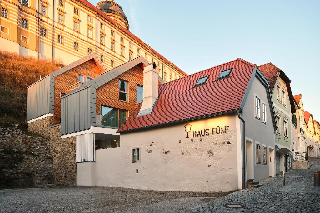 un bâtiment avec un toit rouge dans une rue dans l'établissement Haus Fünf mit 2 Apartments und Studio-Loft mit Terrasse, à Melk