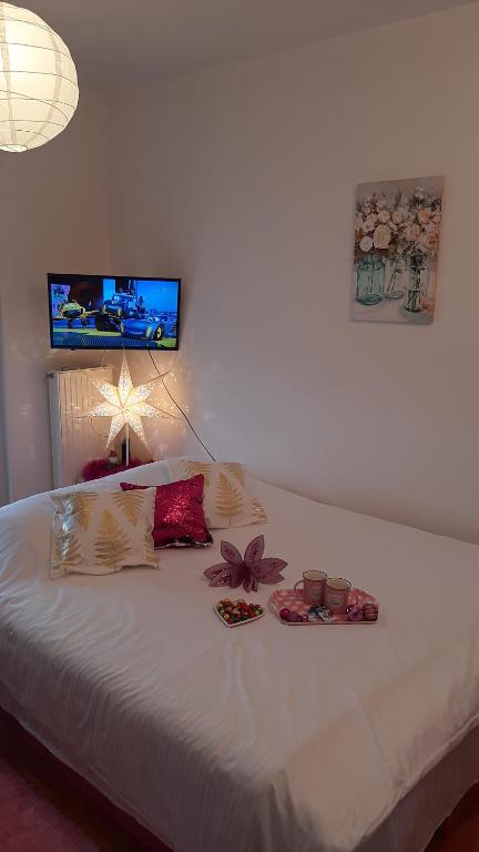 a bedroom with a white bed with flowers on it at Pink Panter Doboj in Doboj