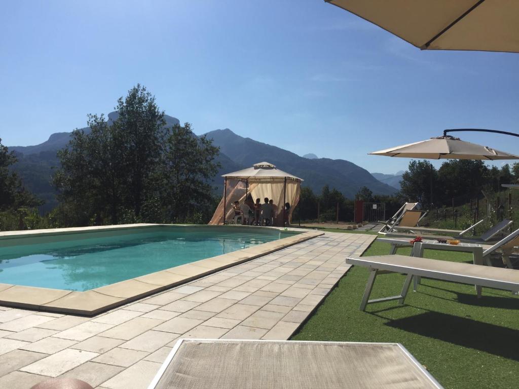 a swimming pool with a table and a gazebo at Agriturismo Il Frutteto in Ghivizzano