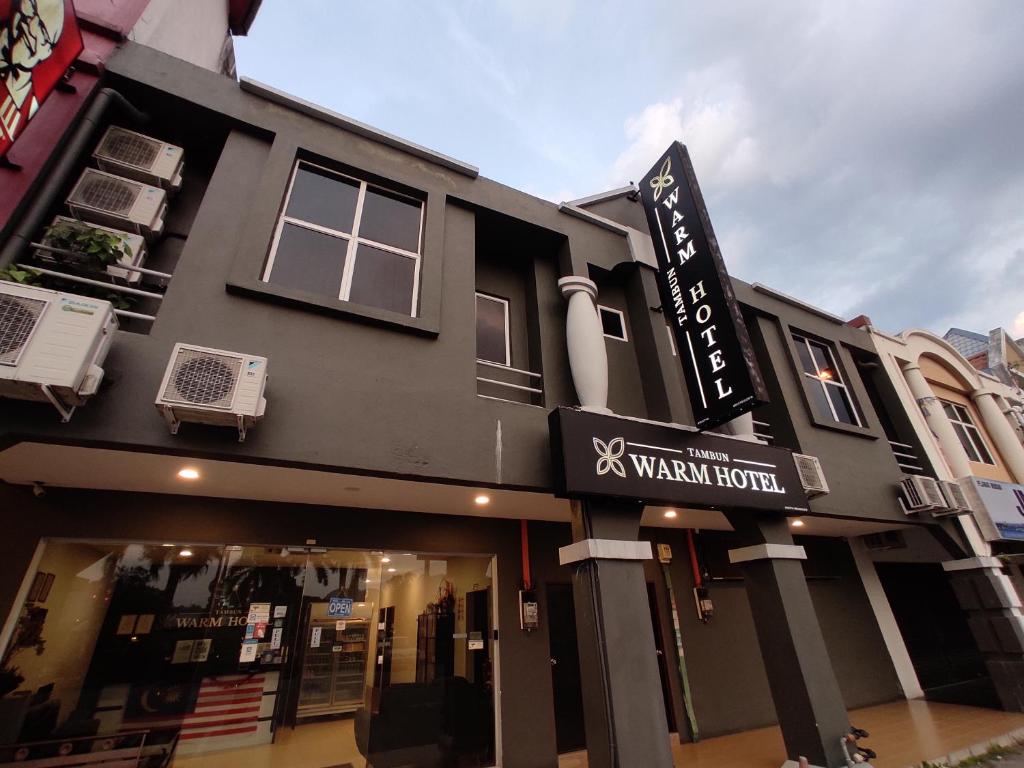 a black building with a sign for a woman hotel at Tambun Warm Hotel in Ipoh