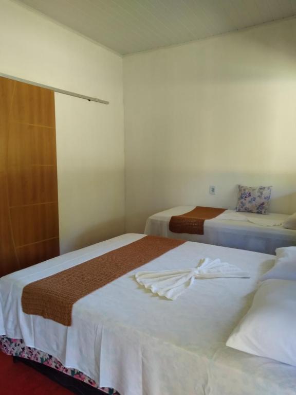 Dos camas en una habitación de hotel con toallas. en Chalé Ilha Verde-Cumuruxatiba, en Cumuruxatiba