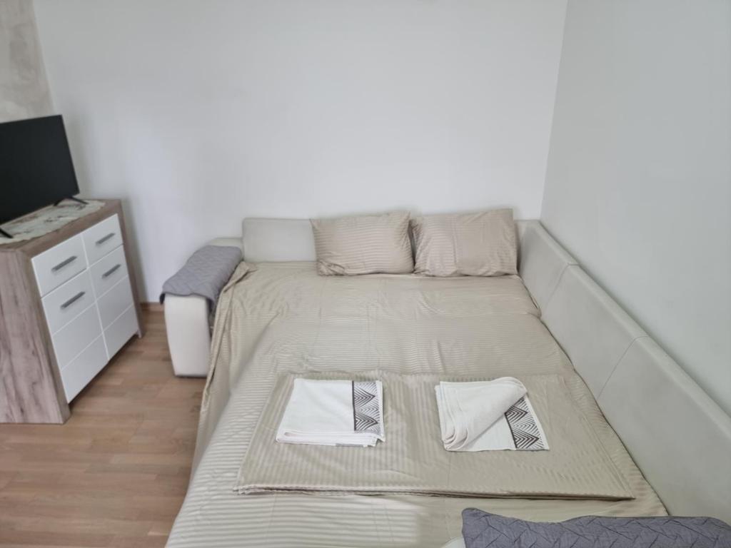 Cama grande en habitación con marco de cama en Klub1, en Podgorica