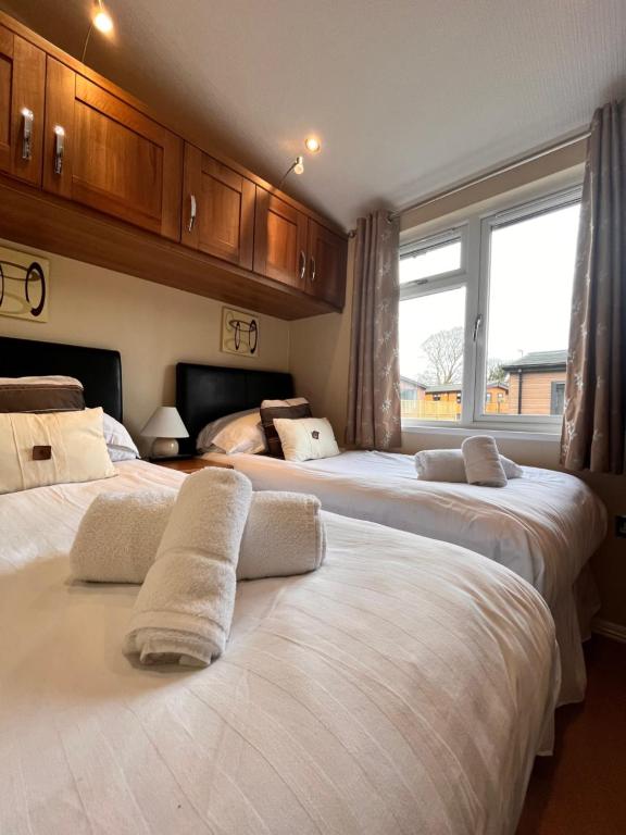 a bedroom with three beds and a large window at Arnside 5 in Warton