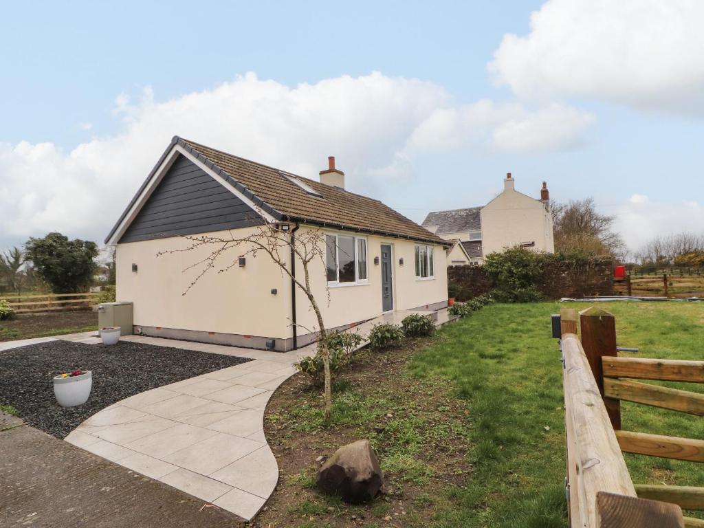 a white house with a pathway in front of it at Cherry Croft in Wigton