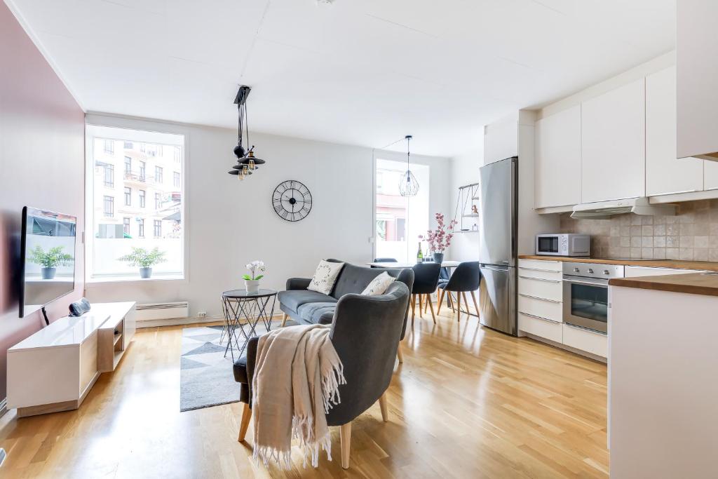 een keuken en een woonkamer met een bank en een tafel bij Charming and cozy - Centrally located in Oslo