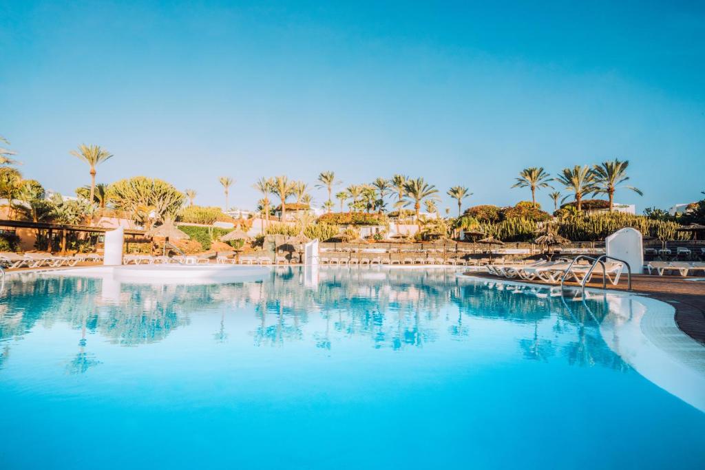une grande piscine avec une fontaine dans un complexe dans l'établissement HL Club Playa Blanca, à Playa Blanca