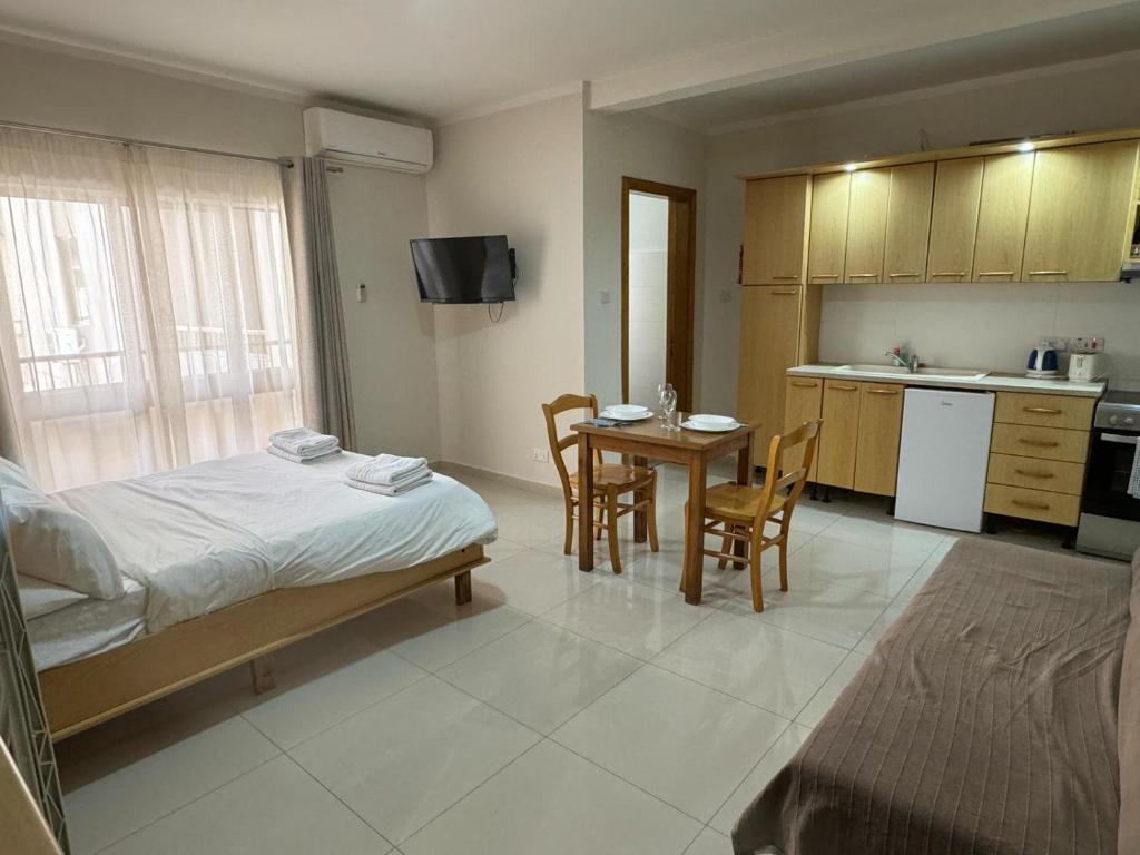 - une chambre avec un lit, une table et des chaises dans l'établissement The Triton, à San Pawl il-Baħar