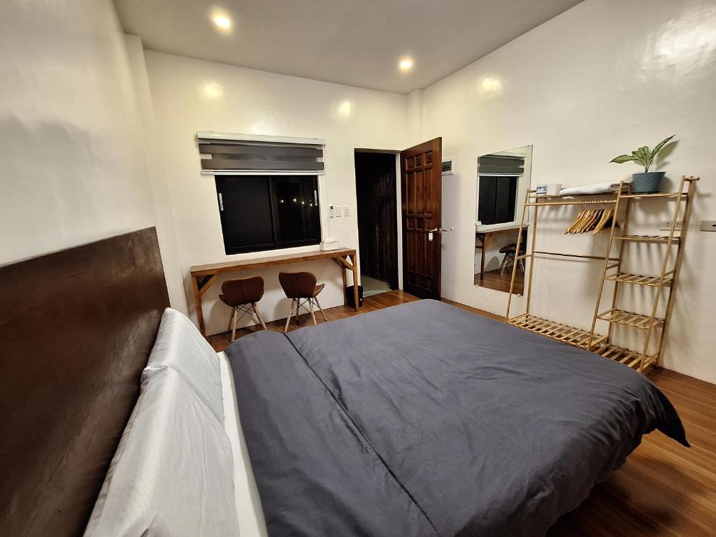 a bedroom with a bed and two chairs in it at Basilia Guest House in Bantayan Island