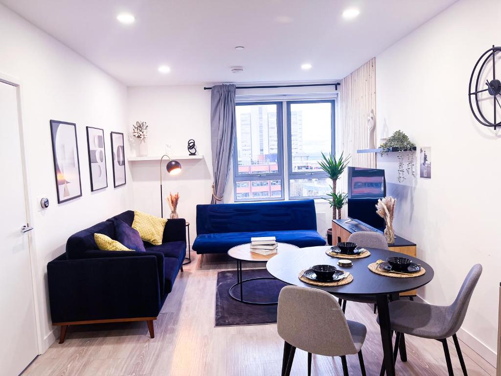 Impeccable 2-Bed Luxury Apartment in Berkshire في براكنيل: غرفة معيشة مع أريكة زرقاء وطاولة