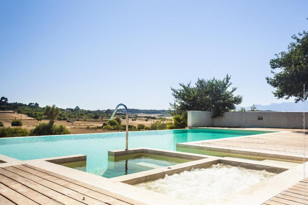 - une piscine avec une fontaine au milieu dans l'établissement Son Morro, à Santa Margalida