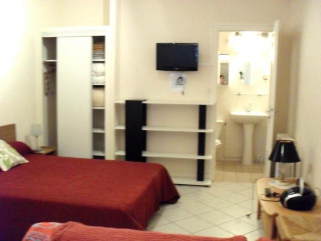 une chambre avec un lit et une télévision au mur dans l'établissement LE SELECT- BALAINE, à Néris-les-Bains