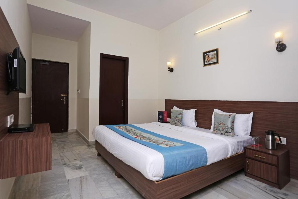 a bedroom with a large bed and a television at Hotel Maan's Heritage in Jaipur