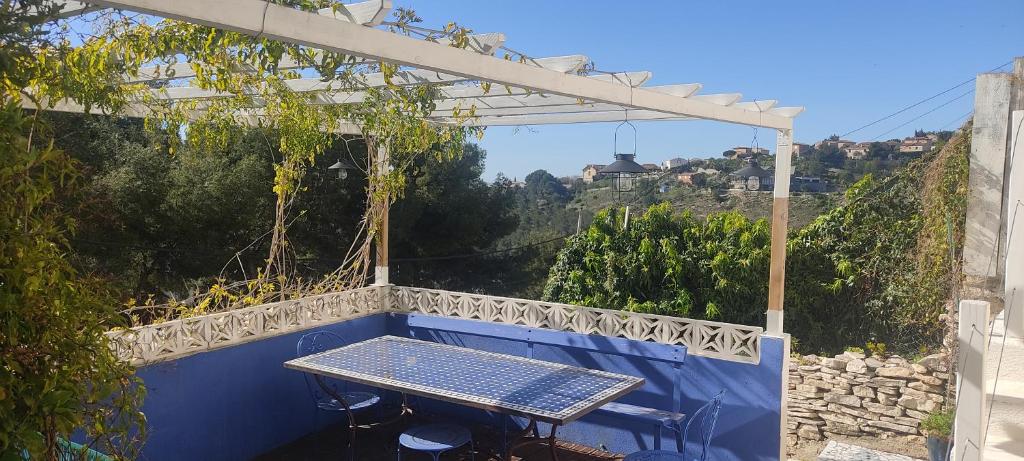 una mesa en un balcón azul con pérgola en Studio indépendant terrasse entre mer et collines, en Marsella