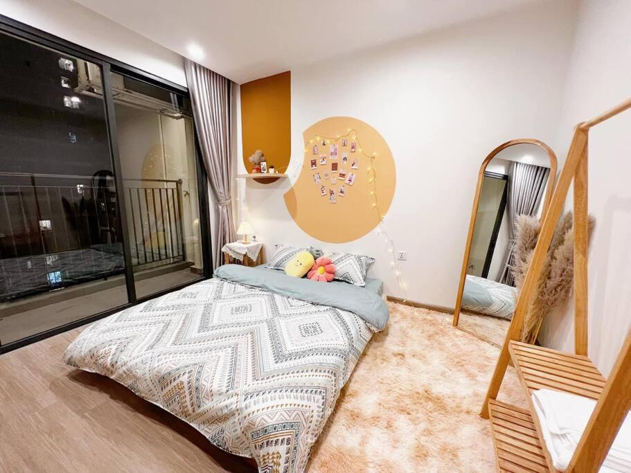 1 dormitorio con cama y espejo en AmHome Premium Vinhome OceanPark en Hanoi
