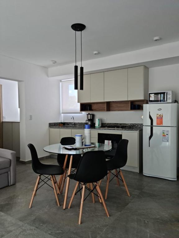 a kitchen with a table and chairs and a refrigerator at Sweet Home in Junín