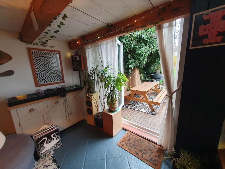 Sofia's Place - Entire 3bedroom house with mezzanine في رغبي: غرفة مع مطبخ مع طاولة ونباتات الفخار