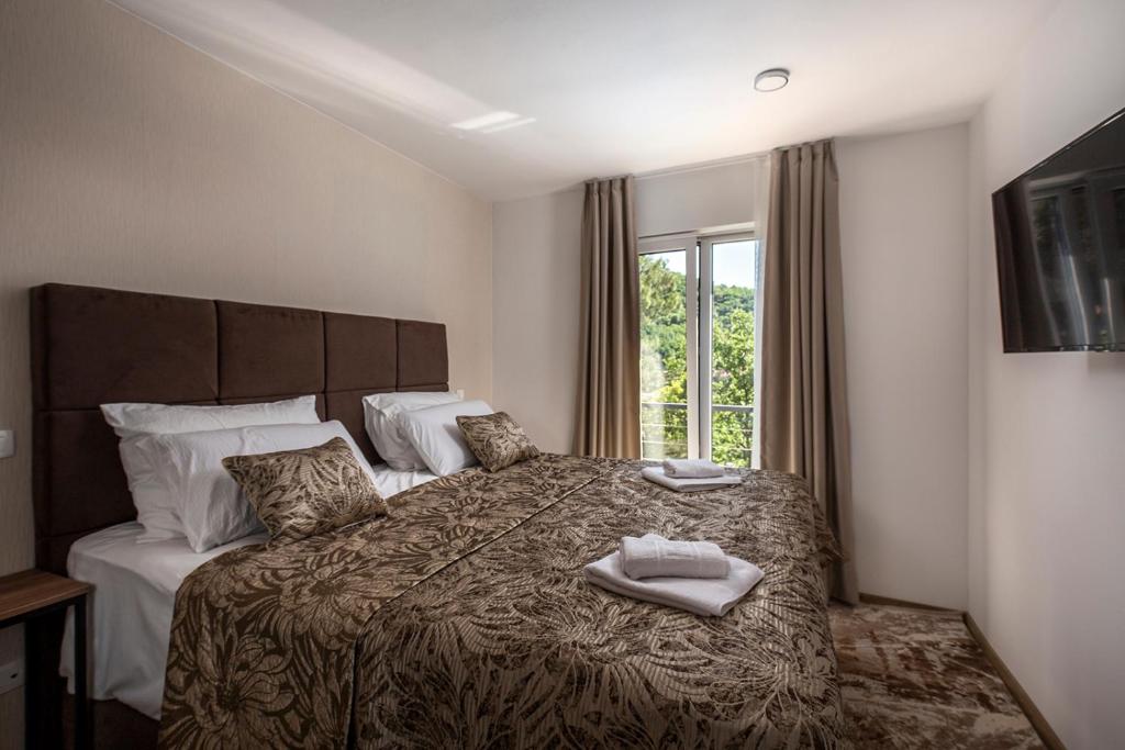 a bedroom with a large bed with towels on it at Villa Visum Mare Unus in Mošćenička Draga