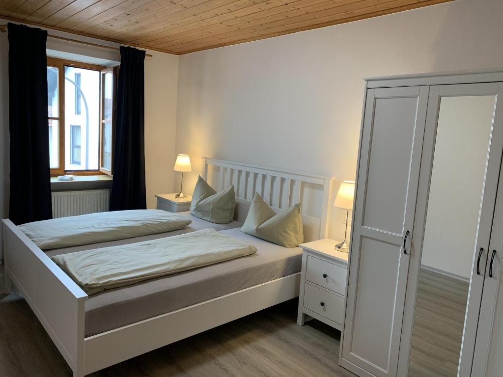 a bedroom with a white bed and two lamps at Zum Zacherwirt in Hengersberg