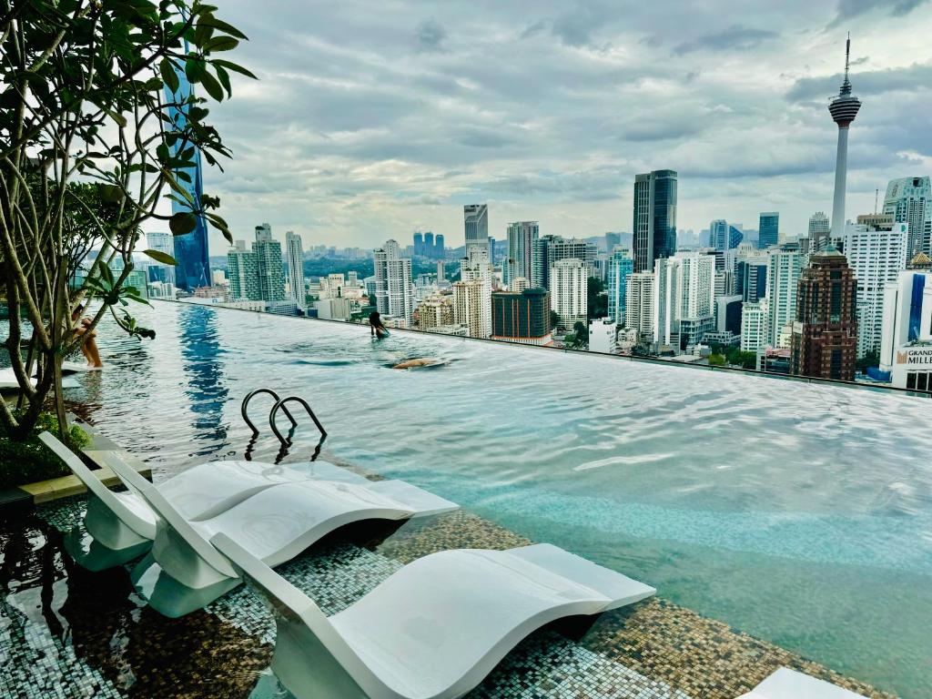 a infinity pool on the roof of a city at Axon Suites Kualalumpur in Kuala Lumpur