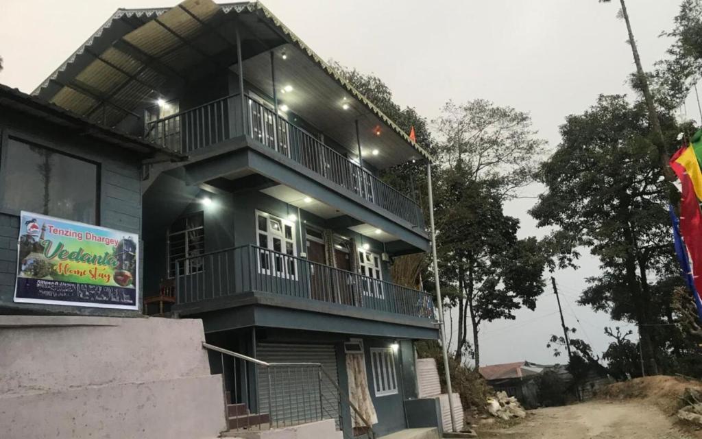 a blue house with a balcony on top of it at Vedanta Homestay by StayApart in Mangpu