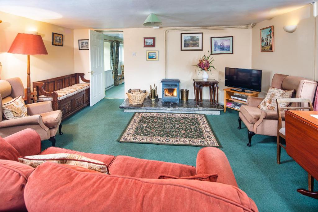 a living room with couches and a fireplace at Lower Cottage Newcastle Emlyn in Cwm-pengraig