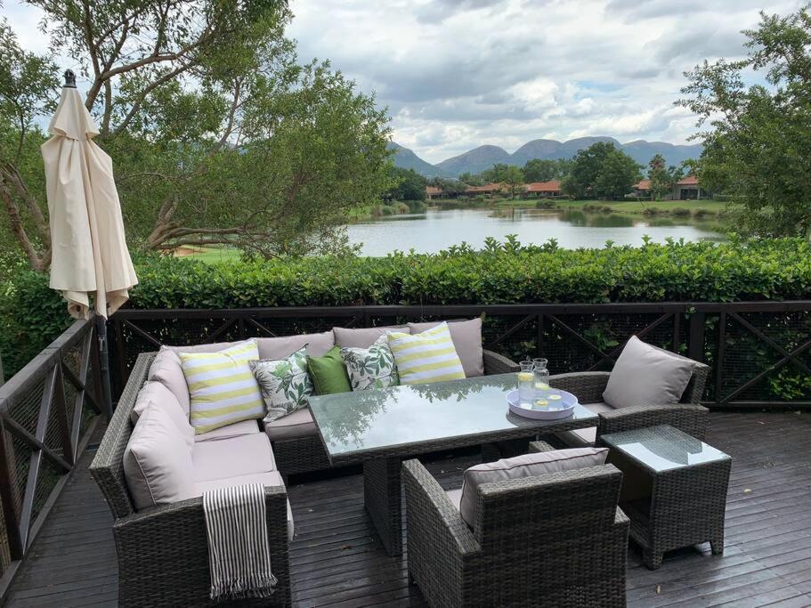 a patio with a couch and a table and an umbrella at Modern Large 5 bedroom Villa in Pecanwood Golf Estate in Hartbeespoort