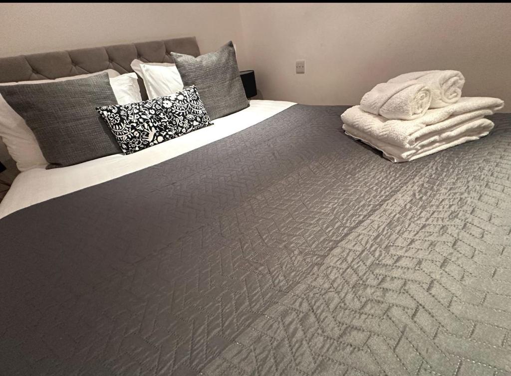 Una cama grande con almohadas y una manta. en Knightsbridge Crystal Haven en Londres
