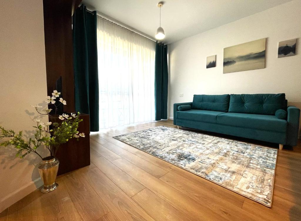 a living room with a blue couch and a rug at Sinaia Walter 20 Apartment w Paid Pool and Free Parking in Sinaia