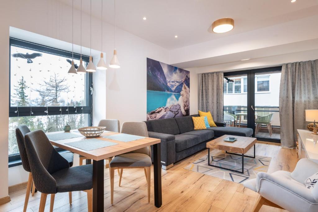 a living room with a couch and a table at TATRYSTAY Armeria Apartments in Štrbské Pleso