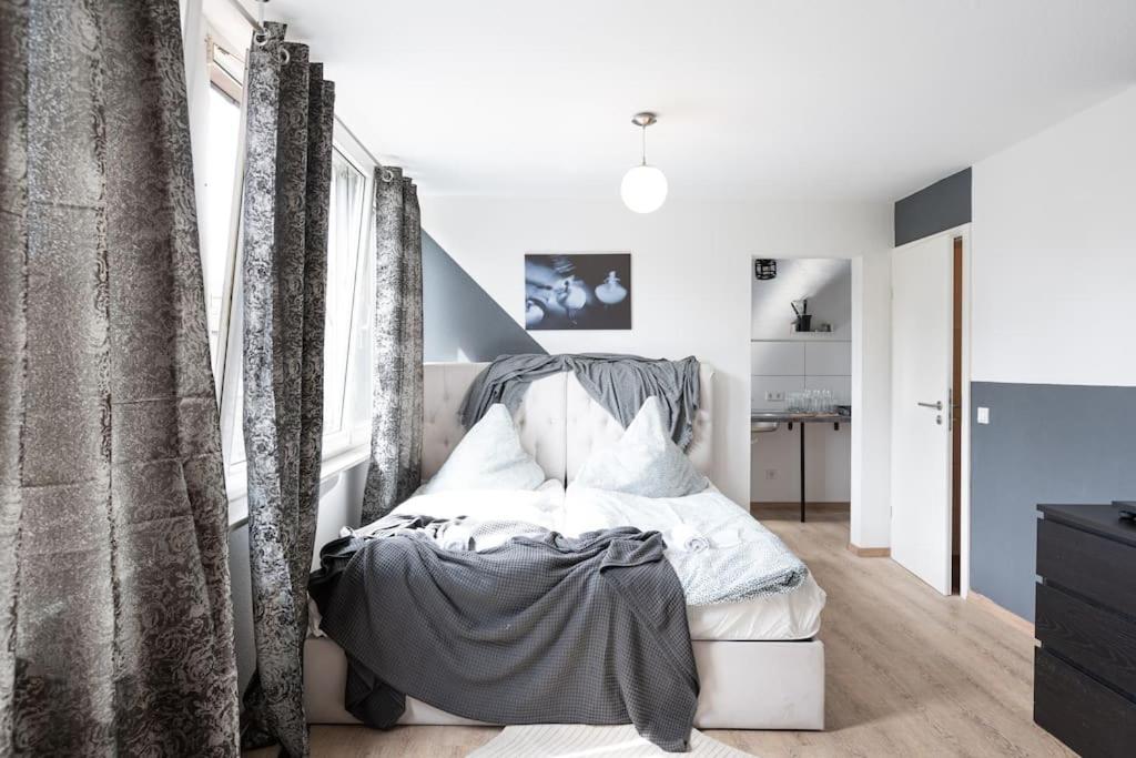 - une chambre avec un lit et des rideaux dans l'établissement - Cozy apartment in the heart of Duisburg with New York Design & Betten & Sofa - 5 Mins Central Station Hbf - Big TV & WiFi -·, à Duisbourg