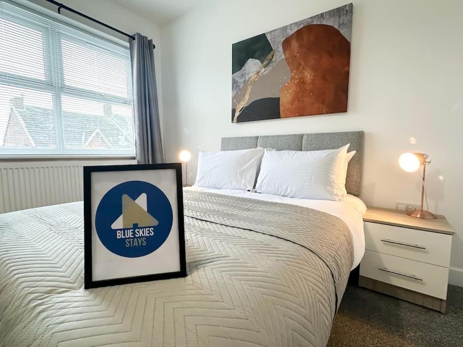 a bedroom with a bed with a sign on it at High Market Place by Blue Skies Stays in Ashington