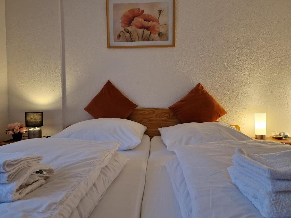 two beds in a hotel room with white sheets at Holiday Apartment near Triberg Waterfall in Triberg