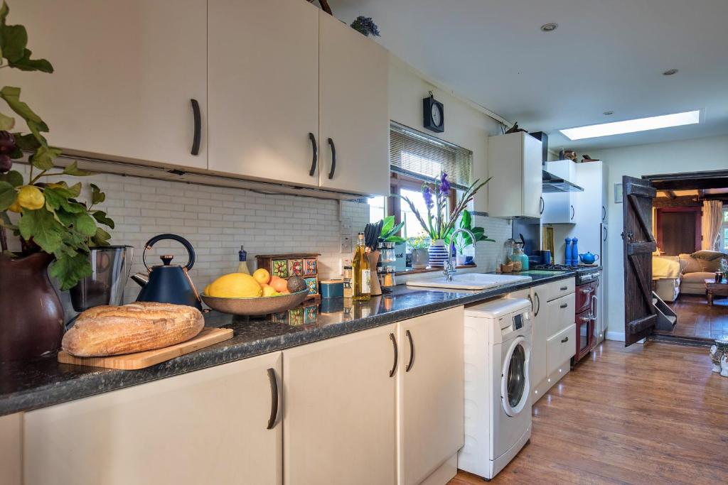 a kitchen with white cabinets and a counter top at Finest Retreats - Bracken in Dormans Land