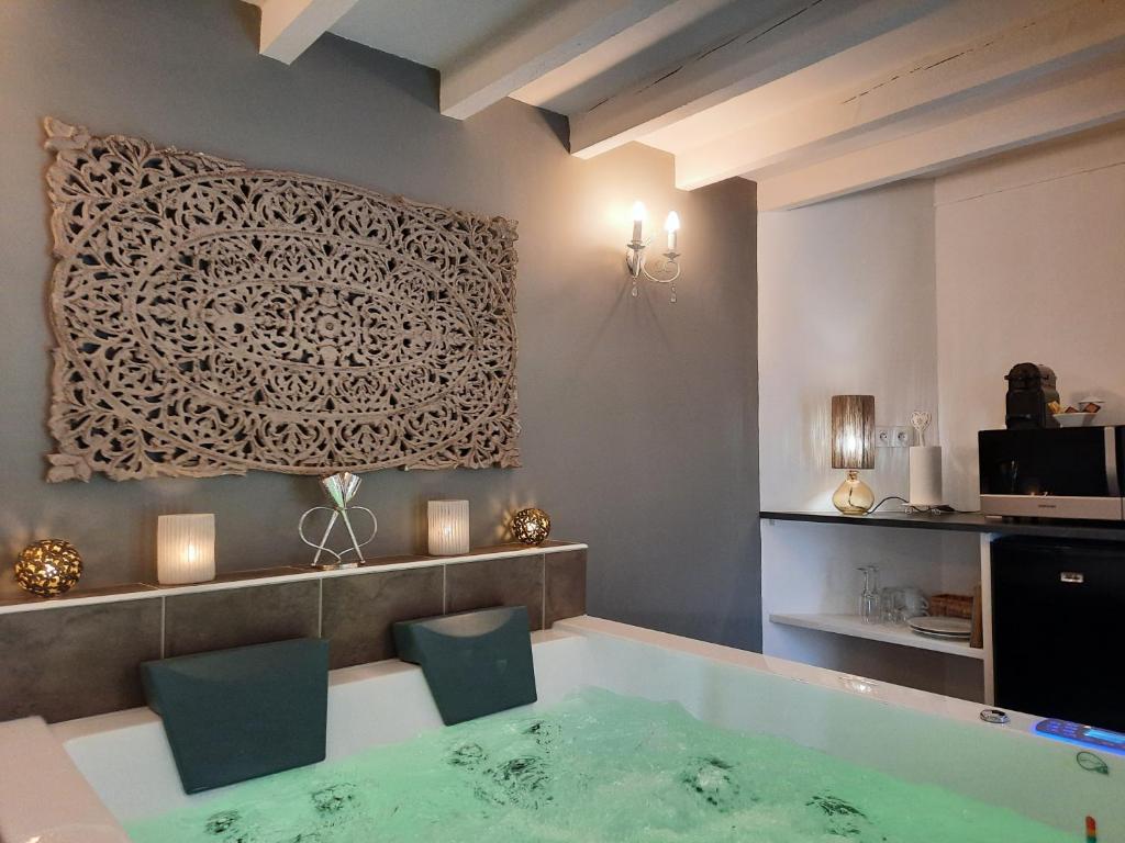 a bath tub with two chairs in a room at CHARME AU FIL DE L'EAU in Vendières
