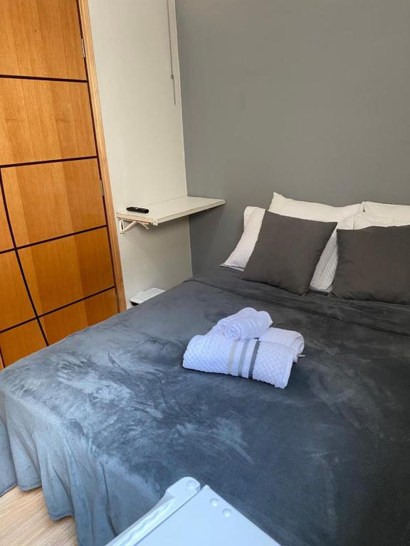 a bedroom with a bed with two towels on it at Quarto privativo no centro 01 in Itapira