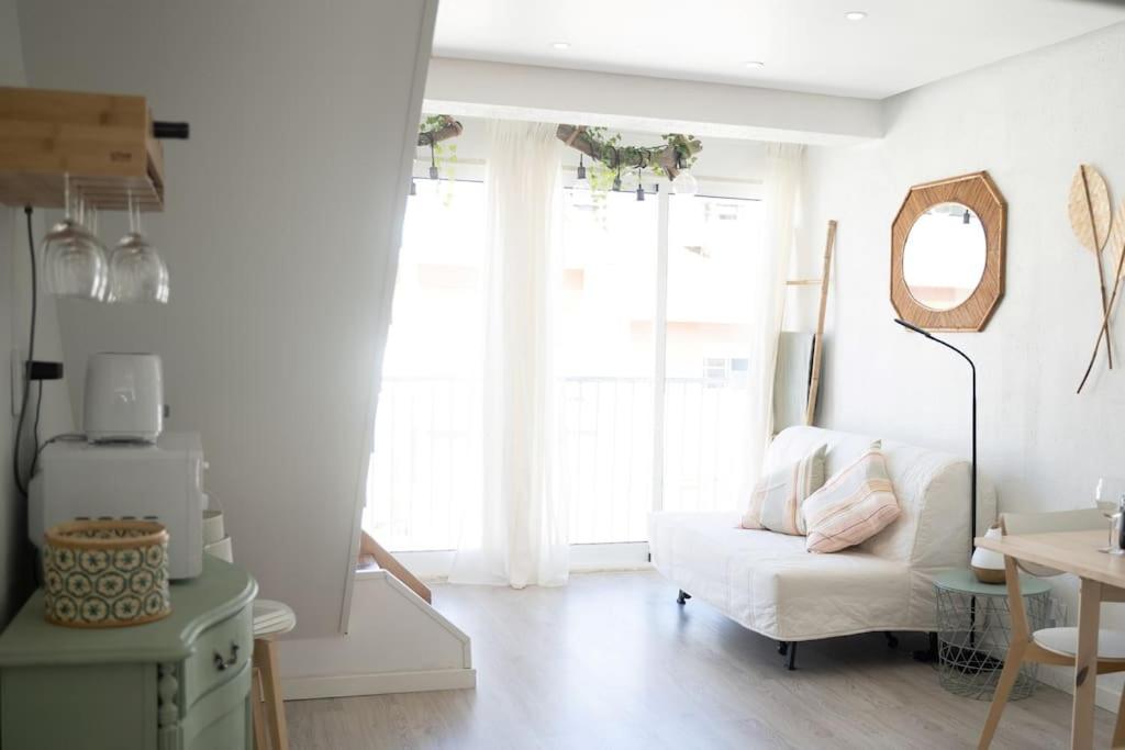 a living room with a white couch and a window at Duplex OverTheTejo, 5 min Belém Tower in Lisbon