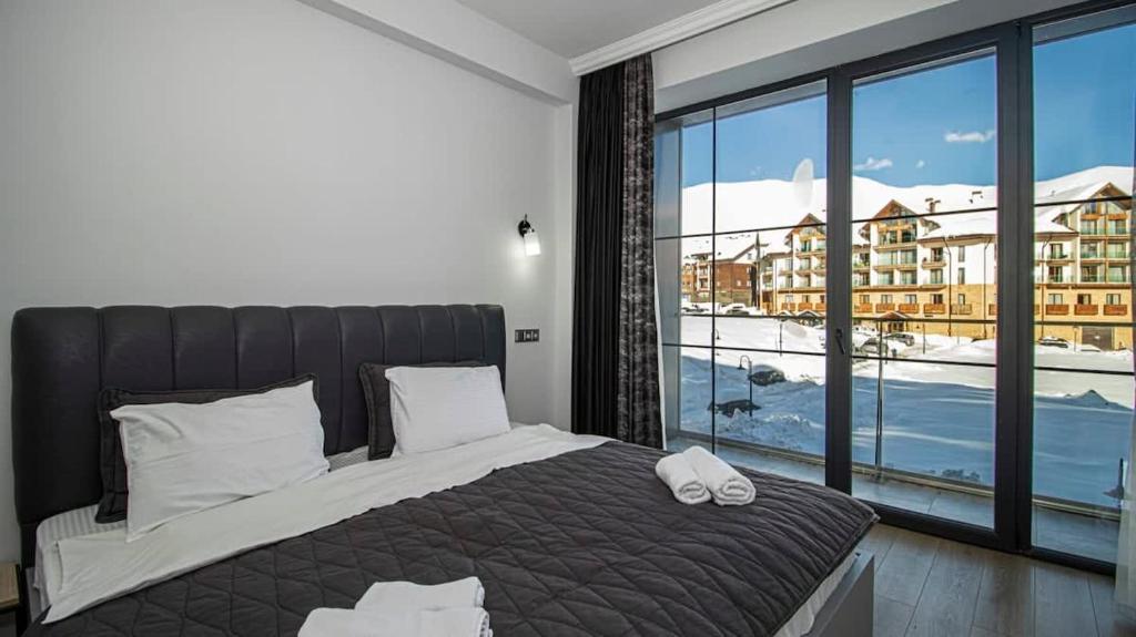 1 dormitorio con cama grande y ventana grande en Lovely 1BR Apartment in Gudauri, en Gudauri