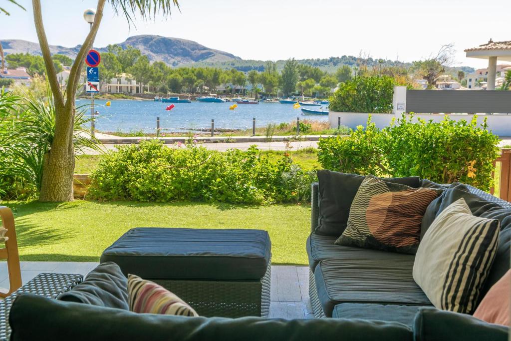 a couch with pillows on a patio with a view of the water at Tarida in Alcudia