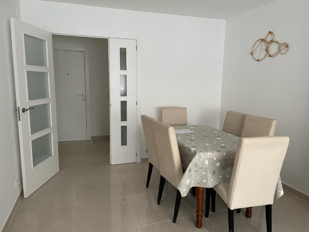 comedor con mesa y sillas blancas en Apartamento Islu, en Peñíscola