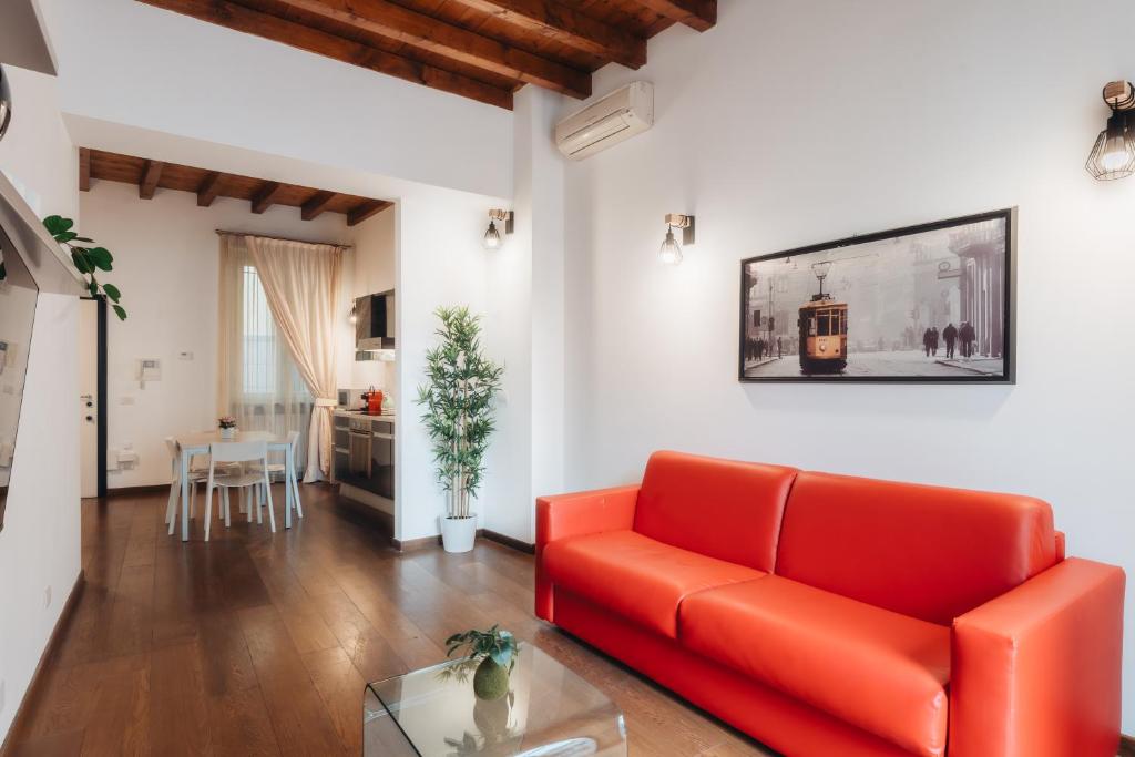 salon z czerwoną kanapą i stołem w obiekcie Charming Milan Apartments Brera - Madonnina w Mediolanie
