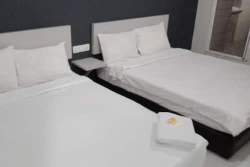 duas camas brancas num quarto com em Hotel Global Sungai Way em Kampong Baharu Sungai Way