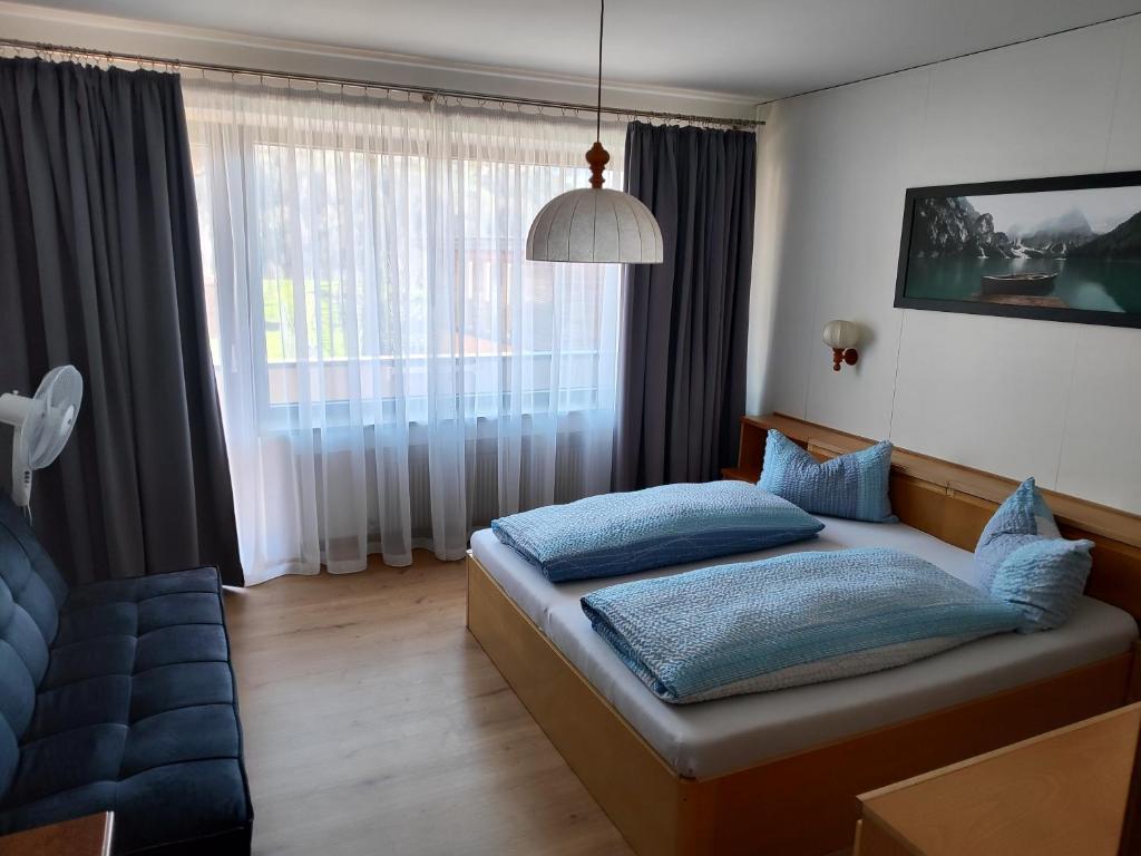 1 dormitorio con cama y ventana grande en B&B Kehrerhof, en Rifiano